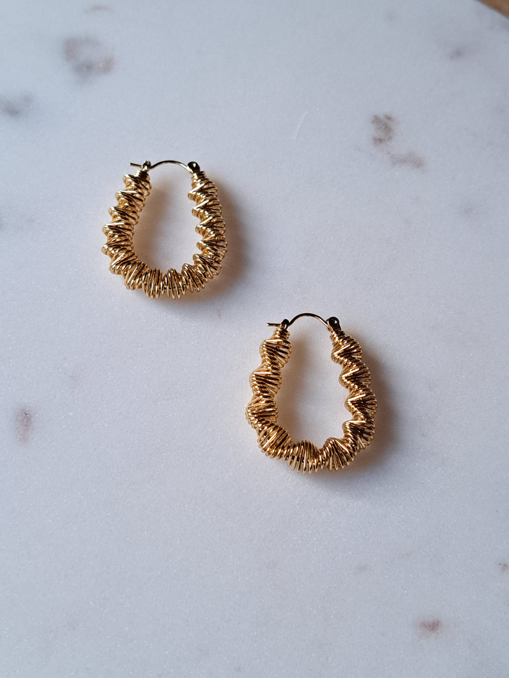 Goudkleurige stainless steel oorbellen. Gedraaid.