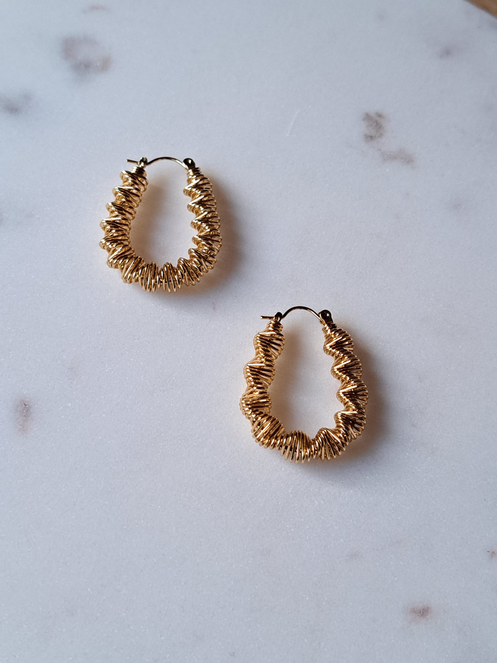 Goudkleurige stainless steel oorbellen. Gedraaid.