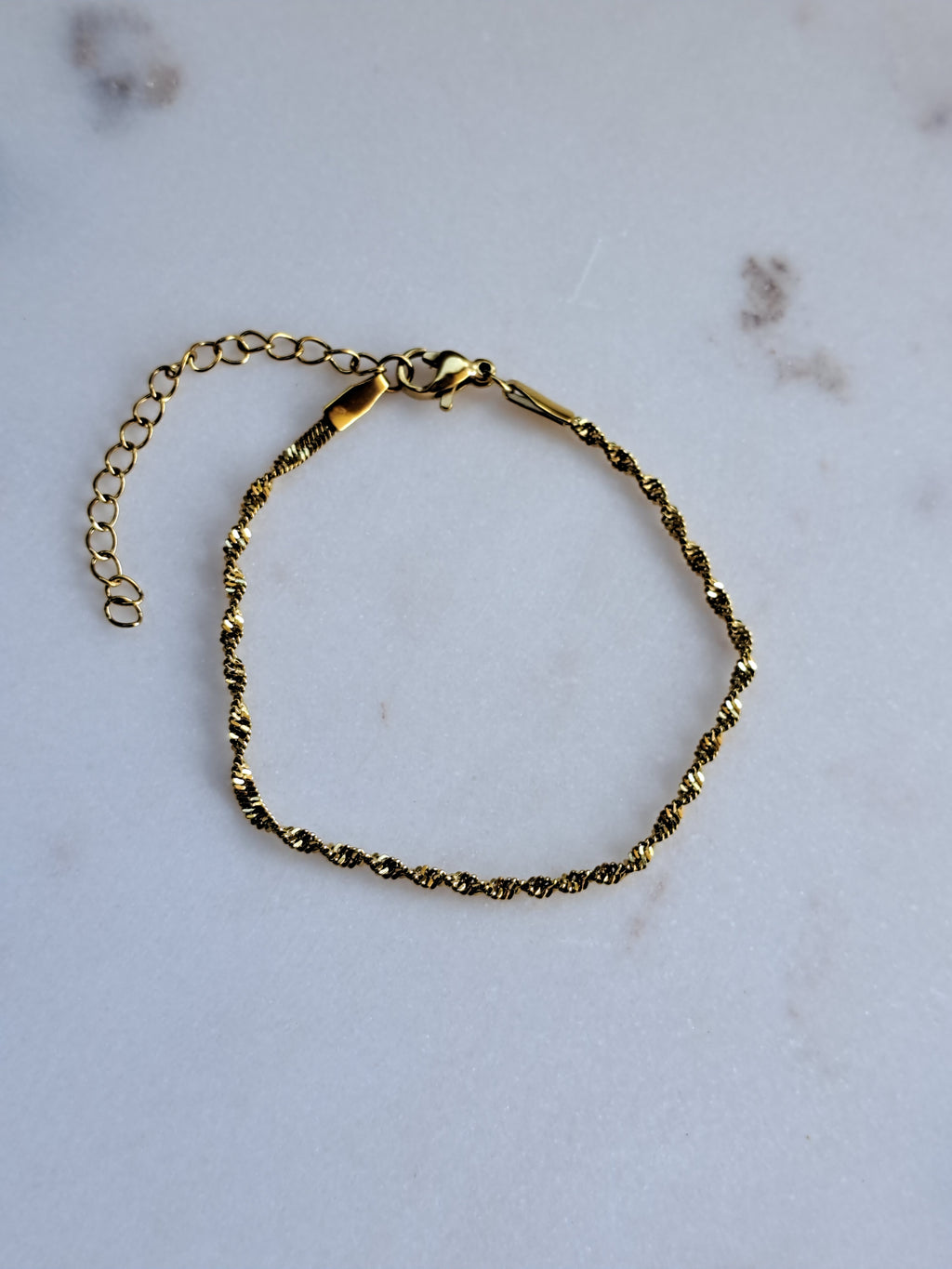 Chique gedraaid stainless steel armbandje, goudkleur