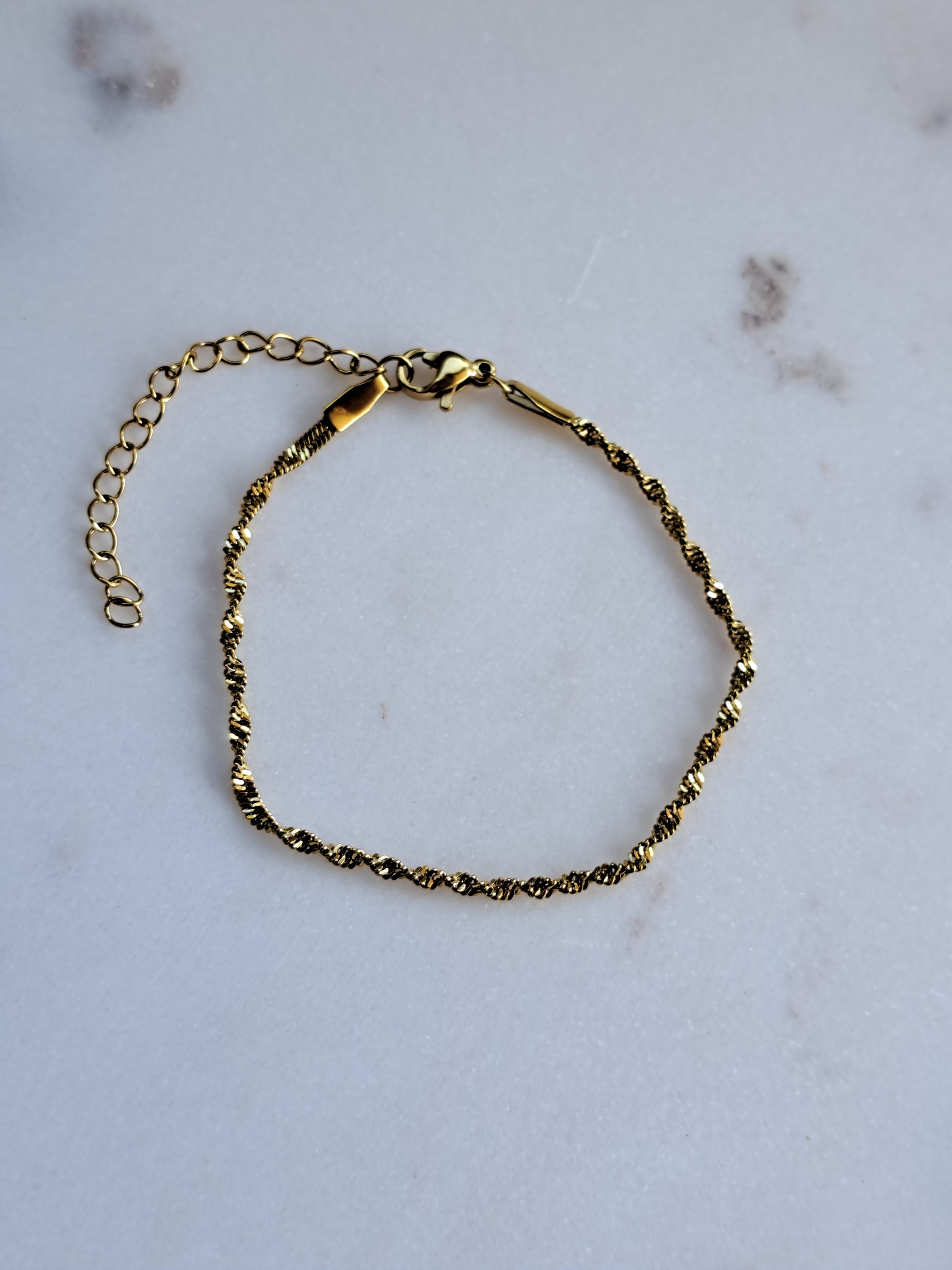 Chique gedraaid stainless steel armbandje, goudkleur