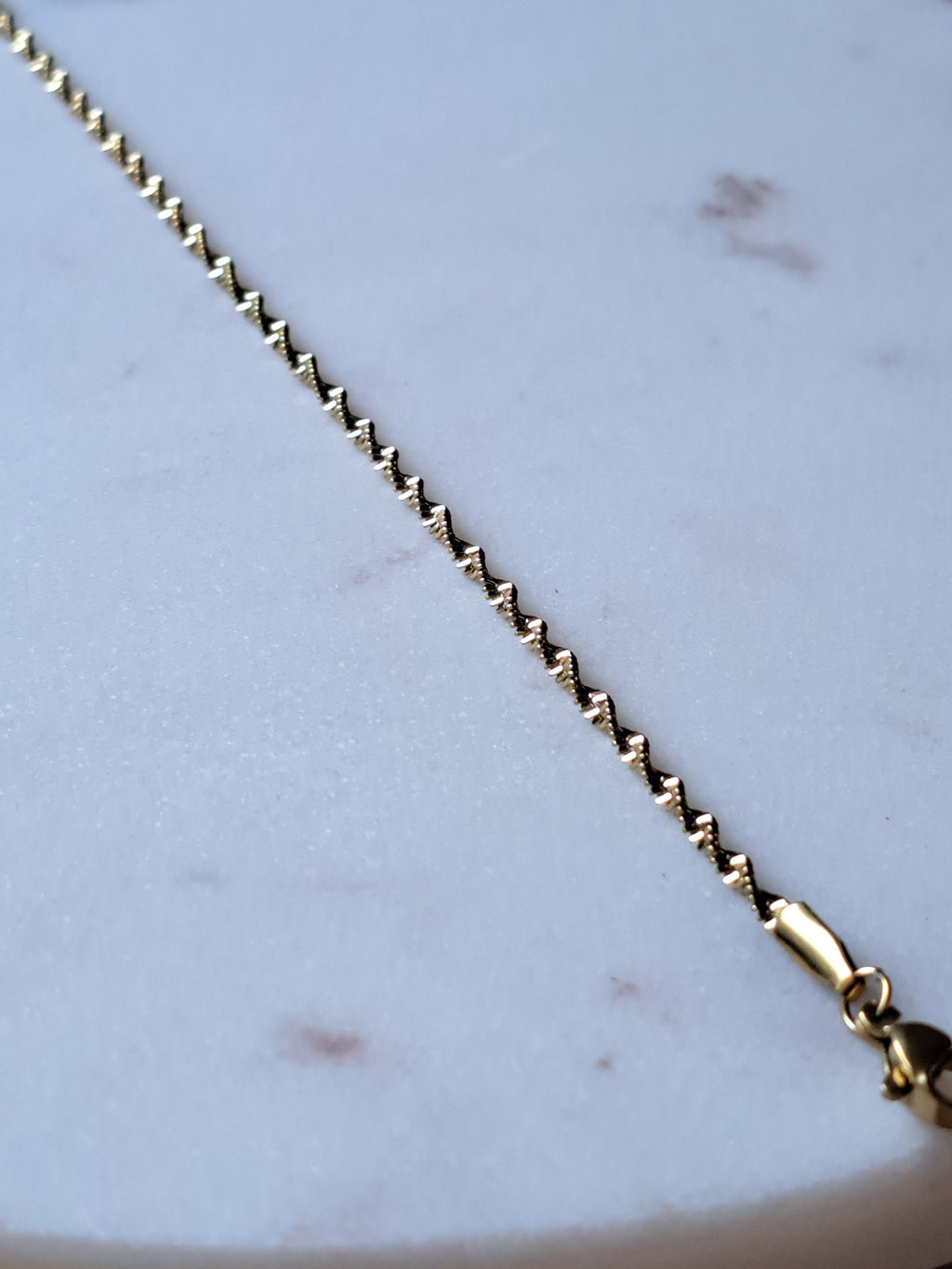 Chique gedraaid stainless steel armbandje, goudkleur