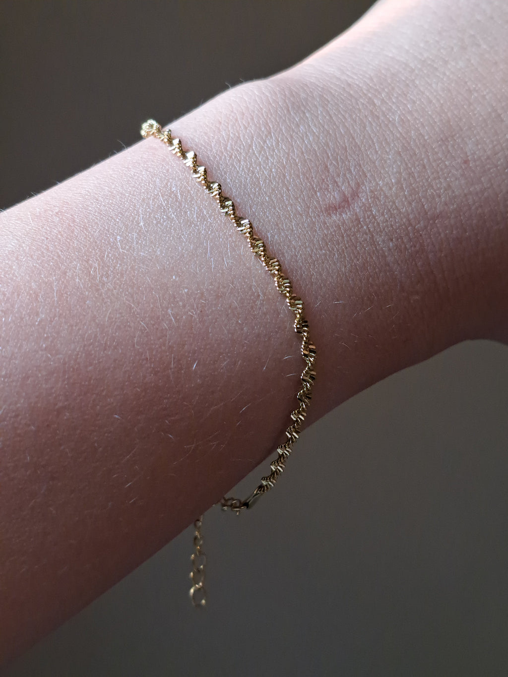 Chique gedraaid stainless steel armbandje, goudkleur