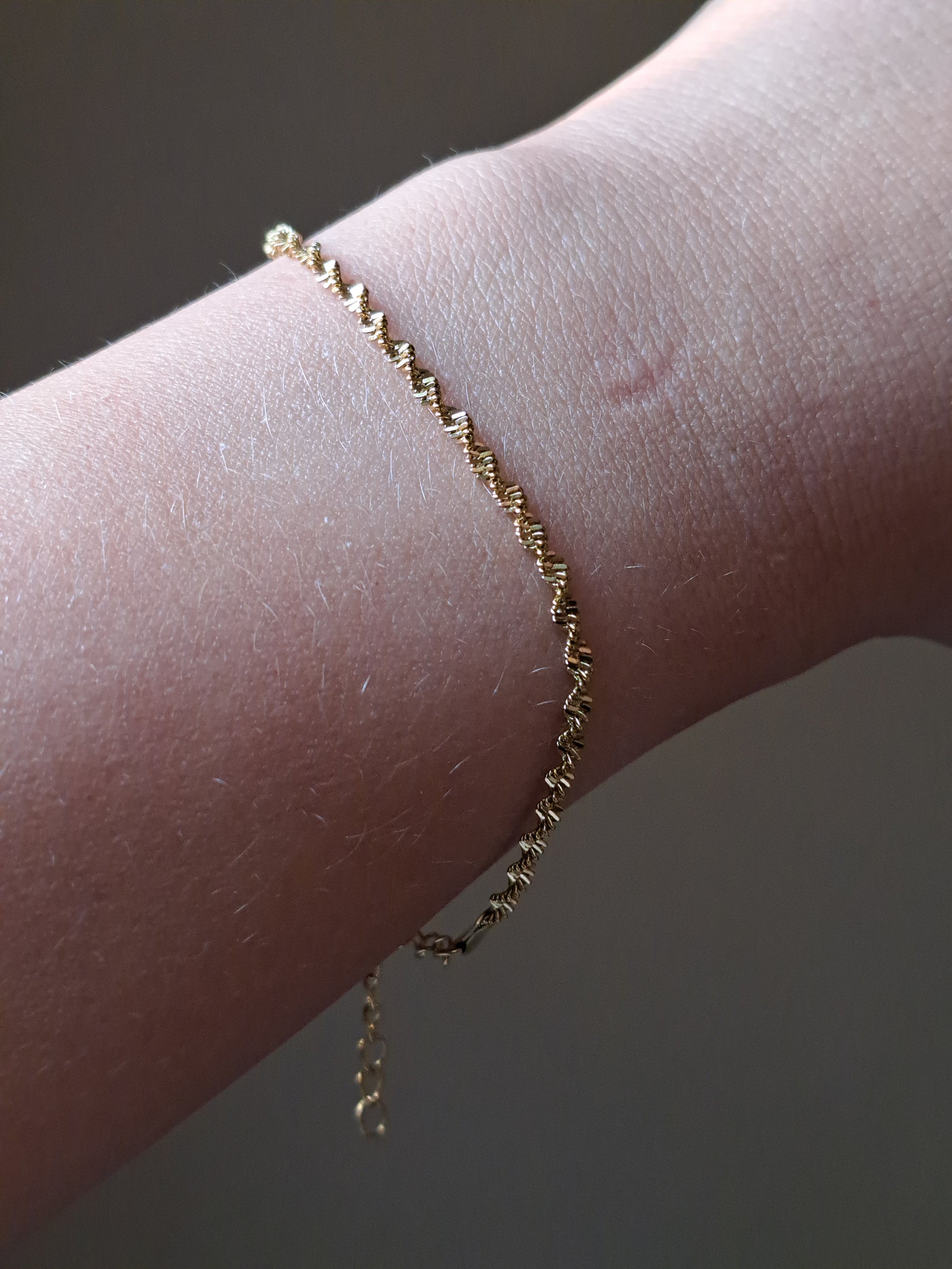 Chique gedraaid stainless steel armbandje, goudkleur