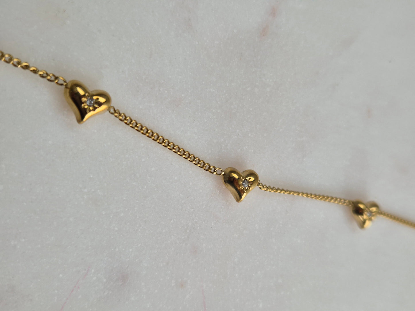 Hartjes armbandje met glittersteentje - goudkleurig