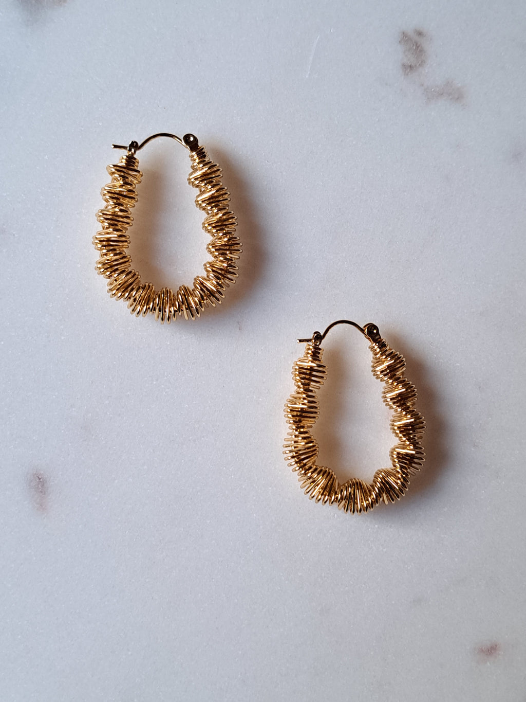 Goudkleurige stainless steel oorbellen. Gedraaid.