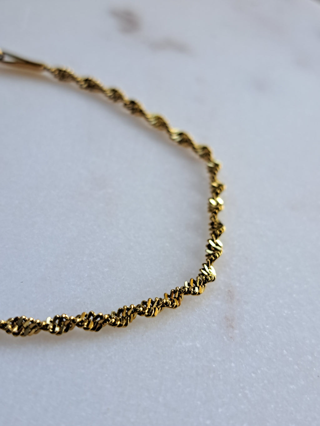 Chique gedraaid stainless steel armbandje, goudkleur